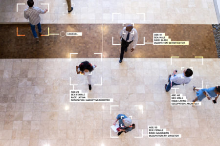 While walking through an office lobby, diverse group of business professionals are identified by facial recognition technology, The information includes personal as well as professional information.